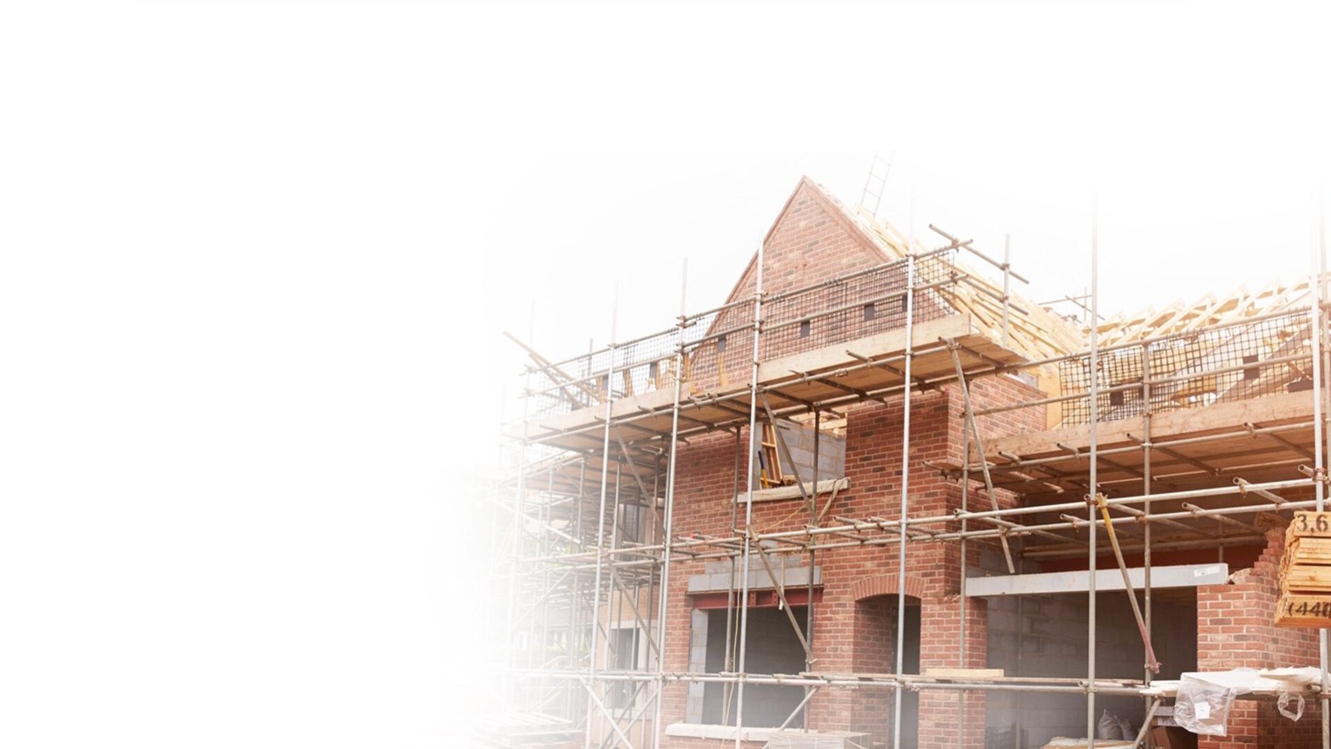 Residential house under construction with scaffolding at sunset